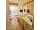 Bright bathroom featuring a glass block shower, tile flooring, and a vanity with countertop space at 18741 E Chinle Dr, Rio Verde, AZ 85263