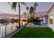 Lush backyard featuring a sparkling pool, manicured lawn, waterfront view and a wrought iron fence at 2043 E Clipper Ln, Gilbert, AZ 85234