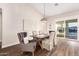 Dining room features a modern table, upholstered chairs, wood floors, and a view of the pool and water outside at 2043 E Clipper Ln, Gilbert, AZ 85234