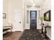 Bright foyer with dark rug, and front door with sidelights, next to a bench, and a side entry door at 2043 E Clipper Ln, Gilbert, AZ 85234