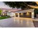 View of the driveway and garage showcasing the spacious three-car capacity and lighting at 2043 E Clipper Ln, Gilbert, AZ 85234