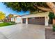 Wide driveway leads to a spacious three-car garage, framed by a mature tree at 2043 E Clipper Ln, Gilbert, AZ 85234