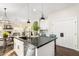 Kitchen island featuring a dark countertop, stainless steel dishwasher, and seating for entertaining at 2043 E Clipper Ln, Gilbert, AZ 85234