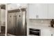Modern kitchen featuring stainless steel refrigerator, oven, and microwave with white cabinets at 2043 E Clipper Ln, Gilbert, AZ 85234