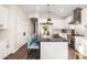 Modern kitchen island featuring a black countertop, pendant lights, and bar stool seating at 2043 E Clipper Ln, Gilbert, AZ 85234