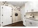 Mud room features white cabinets, a white quartz countertop, and whimsical dog-themed wallpaper at 2043 E Clipper Ln, Gilbert, AZ 85234