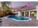 Backyard featuring a refreshing pool with an attached spa and lush landscaping on a brick paver patio at 2043 E Clipper Ln, Gilbert, AZ 85234
