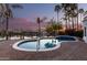 Backyard oasis featuring a beautiful in-ground pool with water views and palm trees at sunset at 2043 E Clipper Ln, Gilbert, AZ 85234