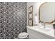 Stylish powder room with a black and white patterned wall, sleek vanity, and modern mirror at 2043 E Clipper Ln, Gilbert, AZ 85234