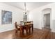 Bright dining room features modern chandelier, wood floors, and white walls at 22236 E Nacoma --, Queen Creek, AZ 85142