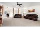 Spacious living room with carpet, ceiling fan, and leather sofas for a comfortable gathering space at 22236 E Nacoma --, Queen Creek, AZ 85142