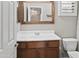 Bathroom with a wood-framed mirror, single sink vanity and a view into the walk-in closet at 2568 E Boston St, Gilbert, AZ 85295