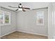 Bedroom featuring wood floors, neutral paint, ceiling fan, and large windows at 2568 E Boston St, Gilbert, AZ 85295
