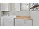 Well-lit laundry room featuring modern appliances, overhead storage, and a functional countertop at 2568 E Boston St, Gilbert, AZ 85295