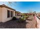 Serene backyard featuring desert landscaping, covered patio, and an outdoor grill at 28798 N 127Th Ave, Peoria, AZ 85383