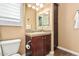 This bathroom features a single sink vanity with a tile backsplash and wood-look floors at 28798 N 127Th Ave, Peoria, AZ 85383