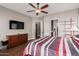 Bedroom featuring hardwood floors, closet access, and a large television at 28798 N 127Th Ave, Peoria, AZ 85383
