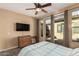 Bedroom with carpet flooring, ceiling fan, television, and outdoor access at 28798 N 127Th Ave, Peoria, AZ 85383