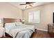 This cozy bedroom features a wood-look floor, ceiling fan and plantation shutters at 28798 N 127Th Ave, Peoria, AZ 85383