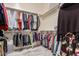Walk-in closet with metal hanging rods and carpeted floor at 28798 N 127Th Ave, Peoria, AZ 85383