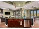 Modern kitchen island with seating, stainless steel appliances, and stylish pendant lights open to living and dining spaces at 28798 N 127Th Ave, Peoria, AZ 85383