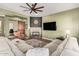 Comfortable living room with fireplace, large sectional sofa, and view into an office space separated by a sliding barn door at 28798 N 127Th Ave, Peoria, AZ 85383
