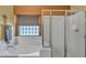 Bathroom featuring separate tub with block glass window and glass-enclosed shower at 2910 E Quiet Hollow Ln, Phoenix, AZ 85024