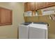 Laundry room with modern front-load washer and dryer, storage cabinets, and shelving at 2910 E Quiet Hollow Ln, Phoenix, AZ 85024