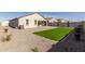 Expansive backyard features artificial turf, low-maintenance gravel landscaping, and a charming paver patio at 38145 W Amalfi Ave, Maricopa, AZ 85138
