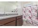 Charming bathroom with granite counters, decorative shower curtain, and a spacious mirror, ideal for modern living at 38145 W Amalfi Ave, Maricopa, AZ 85138