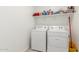 Convenient laundry room equipped with modern washer and dryer, and organized shelving for easy storage at 38145 W Amalfi Ave, Maricopa, AZ 85138