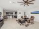 Bright, open living room featuring tile floors, a ceiling fan, and seamless flow to the kitchen at 38145 W Amalfi Ave, Maricopa, AZ 85138