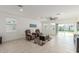 Bright, open living room featuring tile floors, a ceiling fan, and seamless flow to the patio at 38145 W Amalfi Ave, Maricopa, AZ 85138