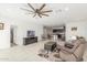 Bright, open living room featuring tile floors, a ceiling fan, and seamless flow to the kitchen at 38145 W Amalfi Ave, Maricopa, AZ 85138
