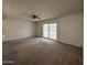 Open living room featuring a ceiling fan and sliding doors with carpet floors offering a cozy and inviting atmosphere at 3849 W Mauna Loa Ln, Phoenix, AZ 85053