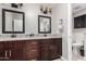 Elegant bathroom featuring dual sinks, dark wood cabinetry, granite counters, and modern lighting at 4037 S Taylor Dr, Tempe, AZ 85282