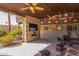 An outdoor living area featuring comfortable seating, a ceiling fan, and a stone-clad entertainment center at 4037 S Taylor Dr, Tempe, AZ 85282