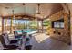 An outdoor living area with a TV, ceiling fans, seating, and views of the pool and backyard at 4037 S Taylor Dr, Tempe, AZ 85282