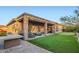 Beautiful backyard featuring a covered patio, built-in BBQ, putting green, and lush landscaping at 40930 N Lambert Trl, Phoenix, AZ 85086