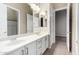 Bathroom featuring double sinks, white cabinetry with bronze fixtures, and access to the shower and bedroom at 40930 N Lambert Trl, Phoenix, AZ 85086