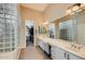 Spacious bathroom featuring dual sinks, a glass block wall, and access to a walk-in closet at 40930 N Lambert Trl, Phoenix, AZ 85086