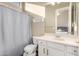 Clean bathroom with a toilet, a shower behind a curtain, and a white vanity with a mirror at 40930 N Lambert Trl, Phoenix, AZ 85086