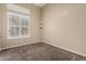 Bedroom featuring neutral carpeting, a large window with blinds, and tan walls at 40930 N Lambert Trl, Phoenix, AZ 85086