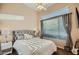 Cozy bedroom featuring a tufted headboard, side tables with lamps, and a sunlit window at 40930 N Lambert Trl, Phoenix, AZ 85086