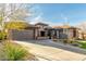 Beautiful desert home featuring a three car garage and long driveway leading up to a well-maintained and manicured front yard at 40930 N Lambert Trl, Phoenix, AZ 85086