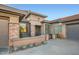 Inviting front entrance featuring stone accents, mature succulents, and a charming gate detail at 40930 N Lambert Trl, Phoenix, AZ 85086