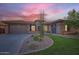 Charming single-story home featuring a lush green lawn, rock garden, and a spacious three-car garage at 40930 N Lambert Trl, Phoenix, AZ 85086