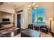 Elegant living room featuring a chandelier, plush seating, and abundant natural light from the large window at 40930 N Lambert Trl, Phoenix, AZ 85086