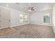 Spacious living room with neutral carpet, ceiling fan, and abundant natural light from multiple windows at 4428 E Wildhorse Dr, Gilbert, AZ 85297
