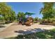 Community playground with a fun play structure, a slide, and mature shade trees at 4428 E Wildhorse Dr, Gilbert, AZ 85297